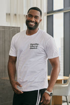 Man wearing a white t-shirt with a logo that reads 'Equality, Liberty, Justice.' on a neutral background