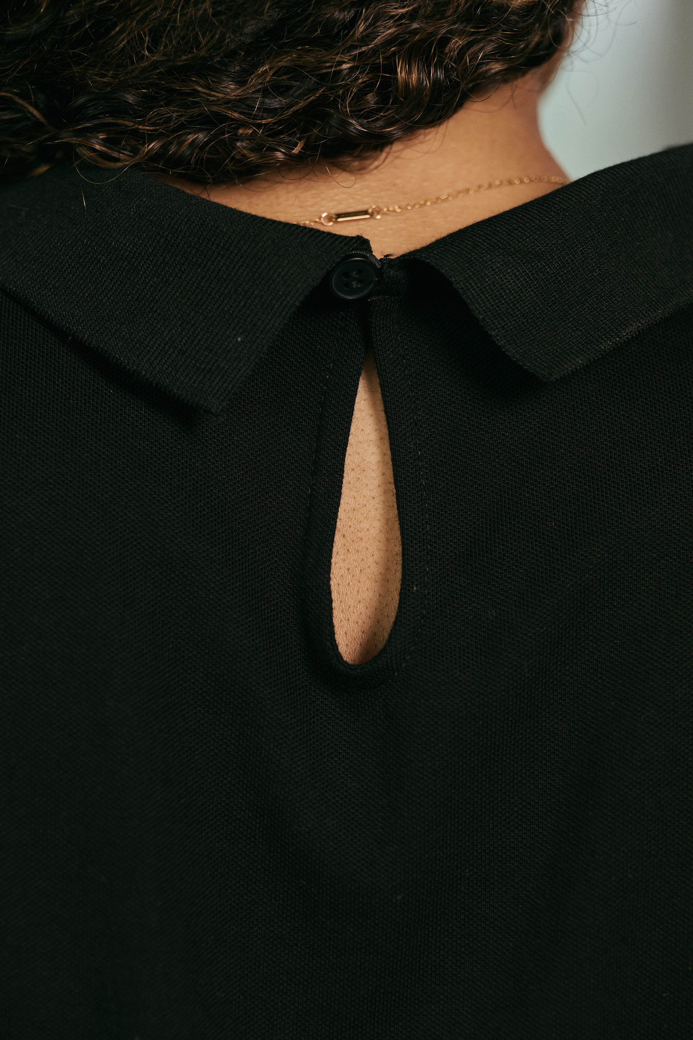 Close-up of a black garment with a unique collar design.