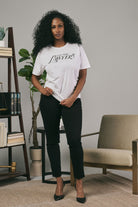 Woman wearing a white t-shirt with text in a modern living room setting