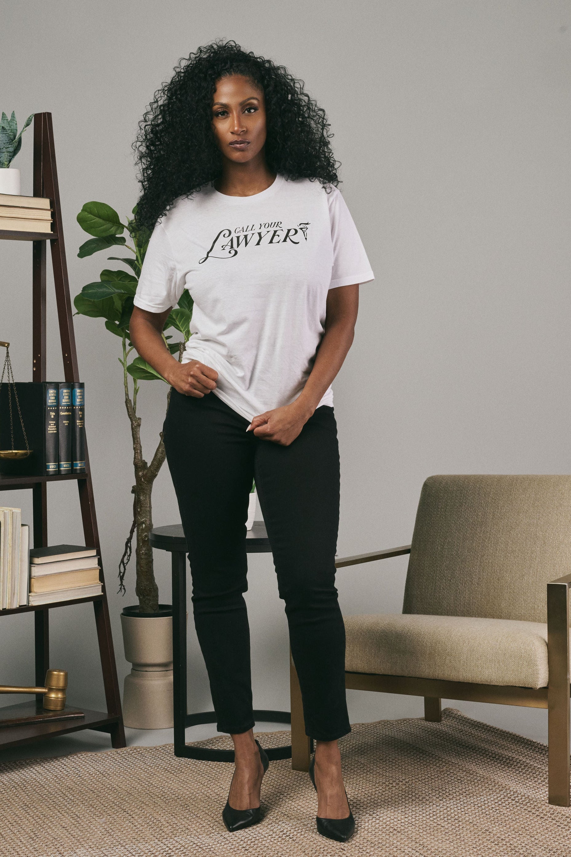 Woman wearing a white t-shirt with text in a modern living room setting