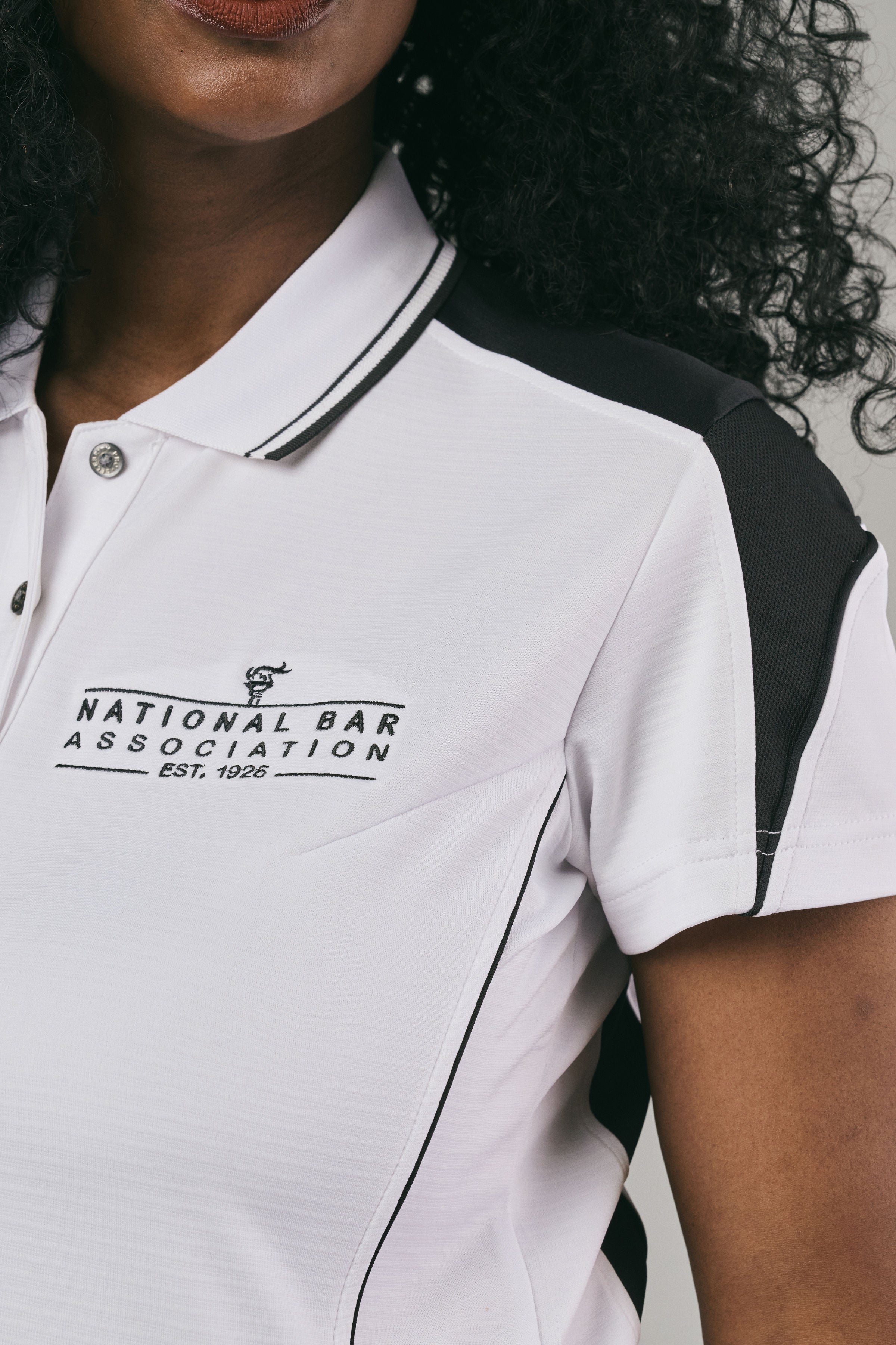 Close up of a woman wearing a white polo shirt with 'National Bar Association' logo