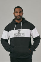 Man wearing a black and white hoodie with 'National Bar Association' logo on a grey background