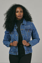Woman wearing a blue denim jacket on a grey background