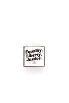 White lapel pin with 'Equality. Liberty. Justice.' text on a white background