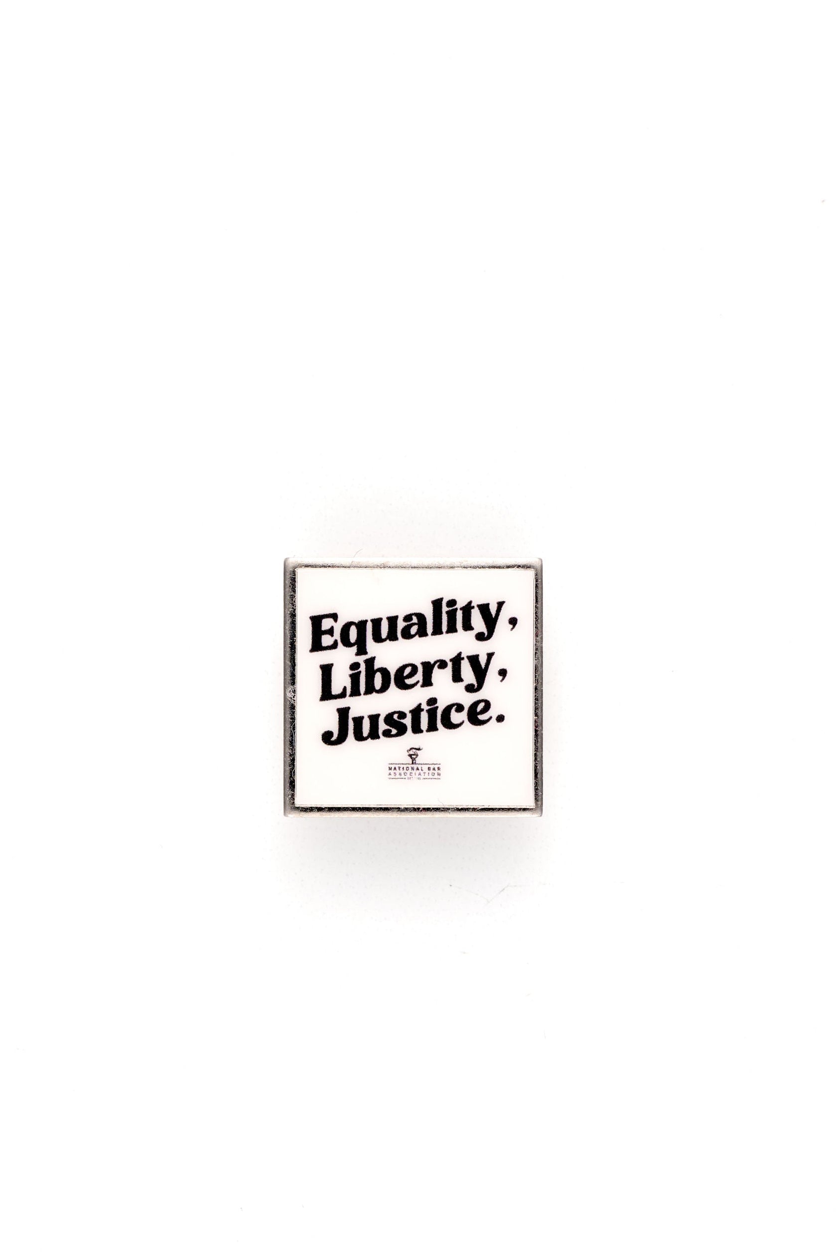 White lapel pin with 'Equality. Liberty. Justice.' text on a white background