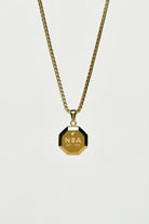 Gold necklace with an NBA pendant on a light grey background