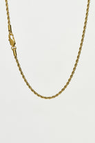 Gold rope chain necklace on a white background