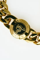 Gold chain bracelet with a National Bar Association logo on a white background
